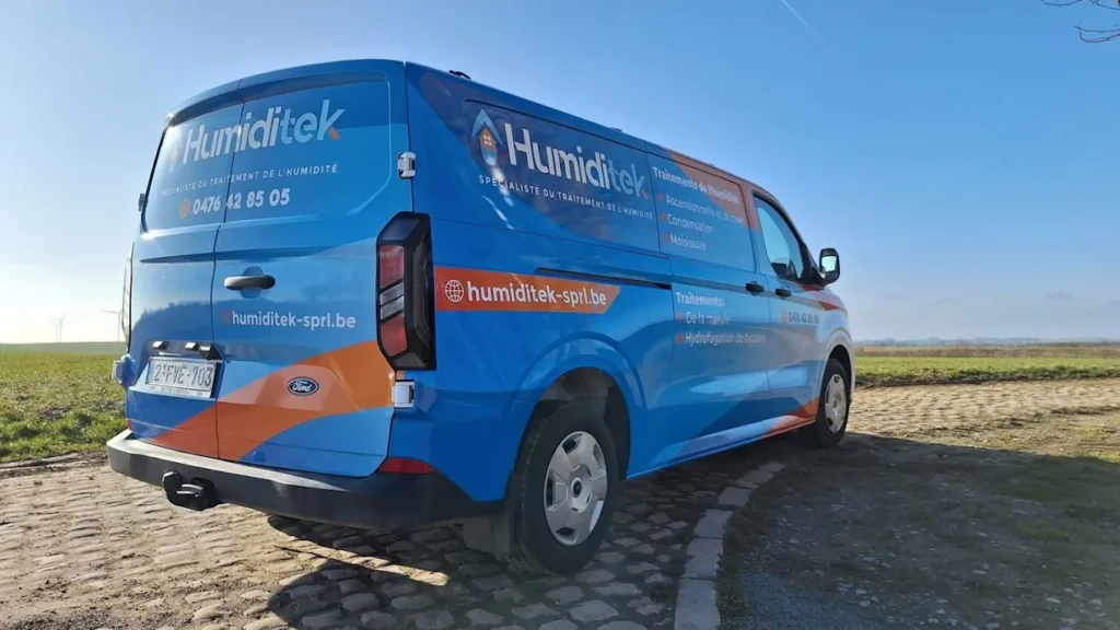 Camionnette de l’entreprise Humiditek en route vers un chantier, avec logo visible sur la carrosserie.