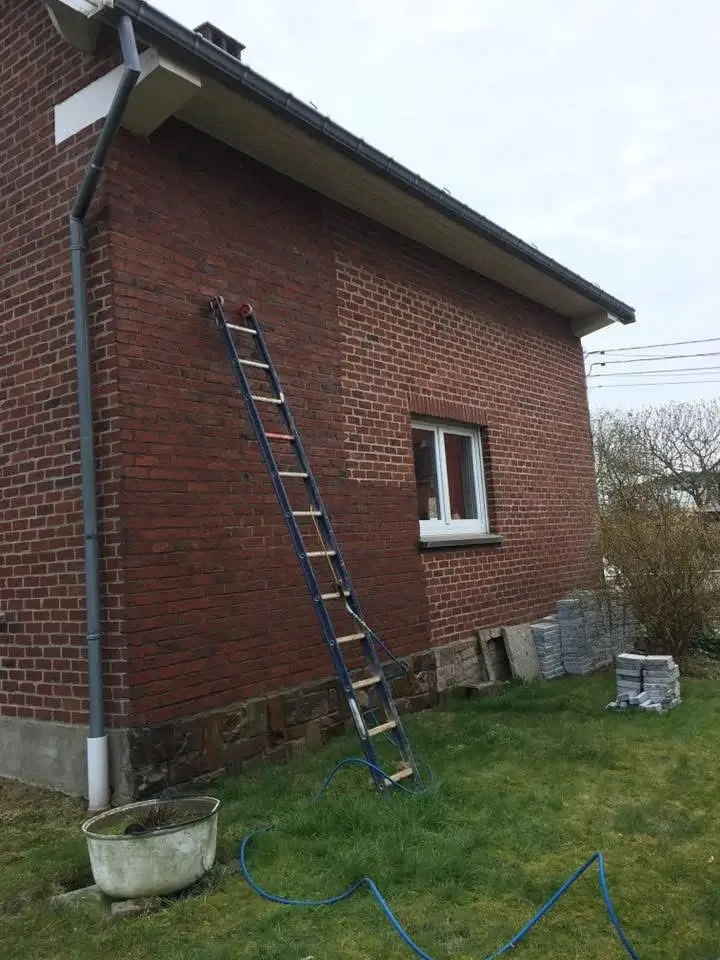 Application d’un hydrofuge sur une façade en brique, avec pulvérisation du produit pour protéger contre l’humidité et les infiltrations.