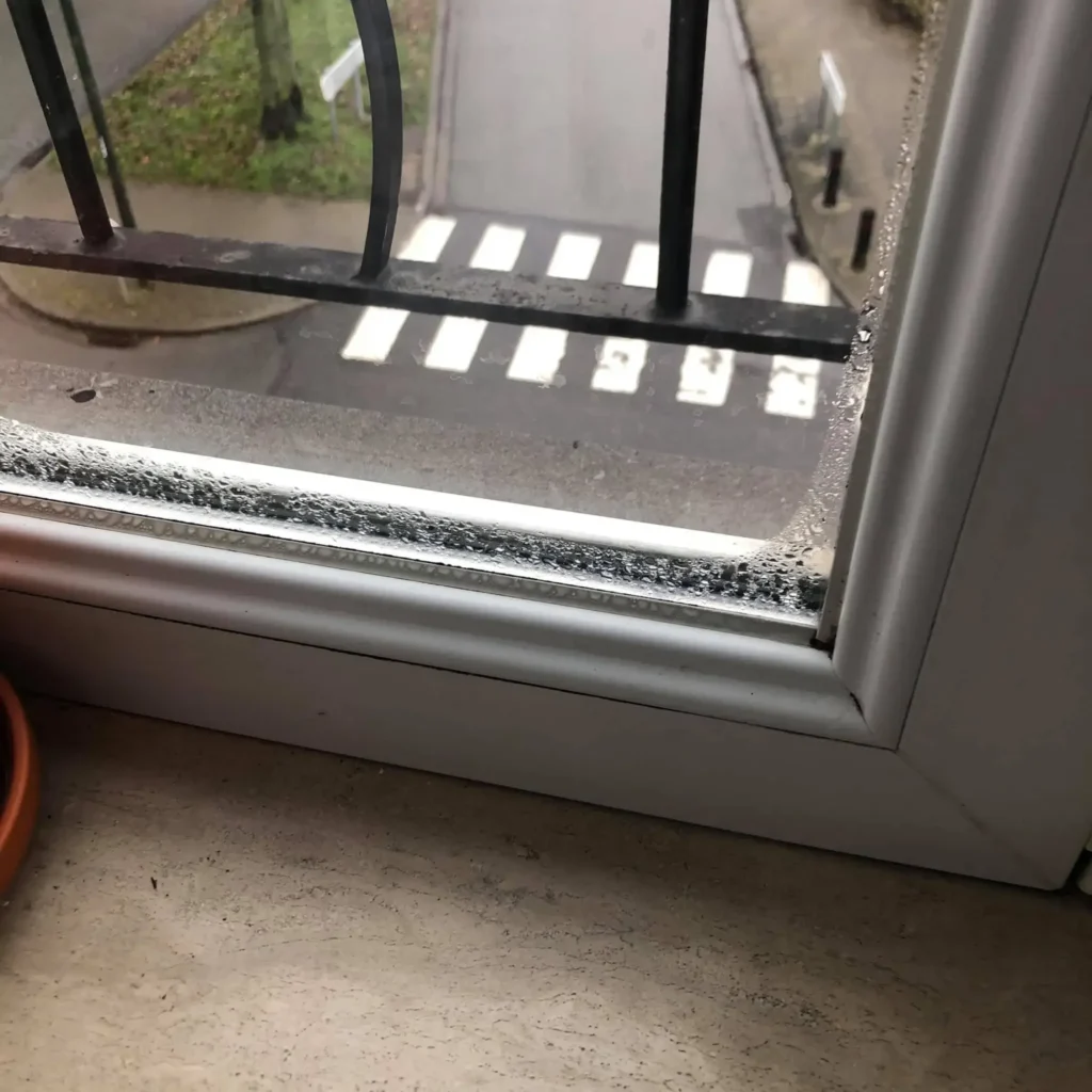 Fenêtre avec condensation importante, gouttes d’eau visibles sur le vitrage, indiquant un problème d’humidité intérieure.