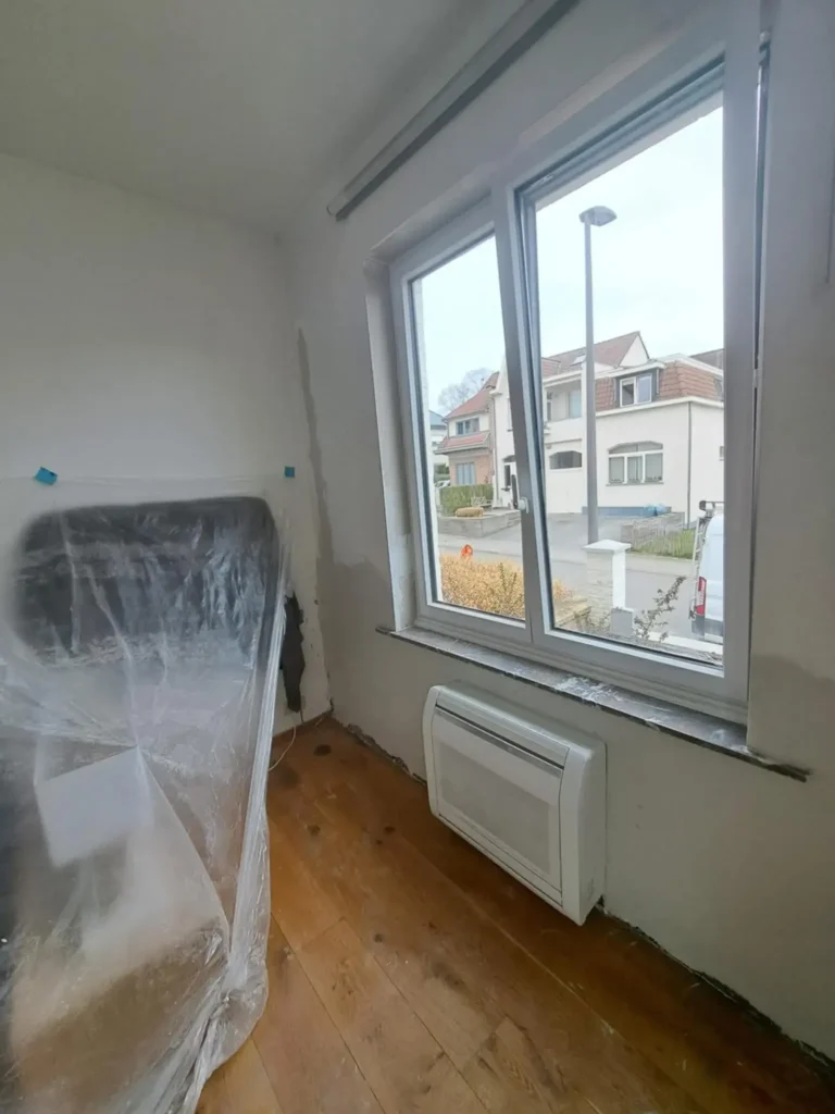 Travail d’assèchement d’un mur humide avec un équipement de déshumidification et préparation de la surface.