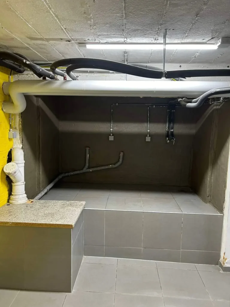Cave traitée contre l’humidité avec murs en pierre et caisson carrelé installé, sol propre et sec.
